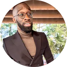 Man wearing glasses and brown blazer