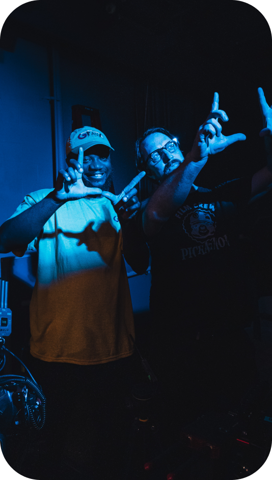 Two people making hand signs in blue light