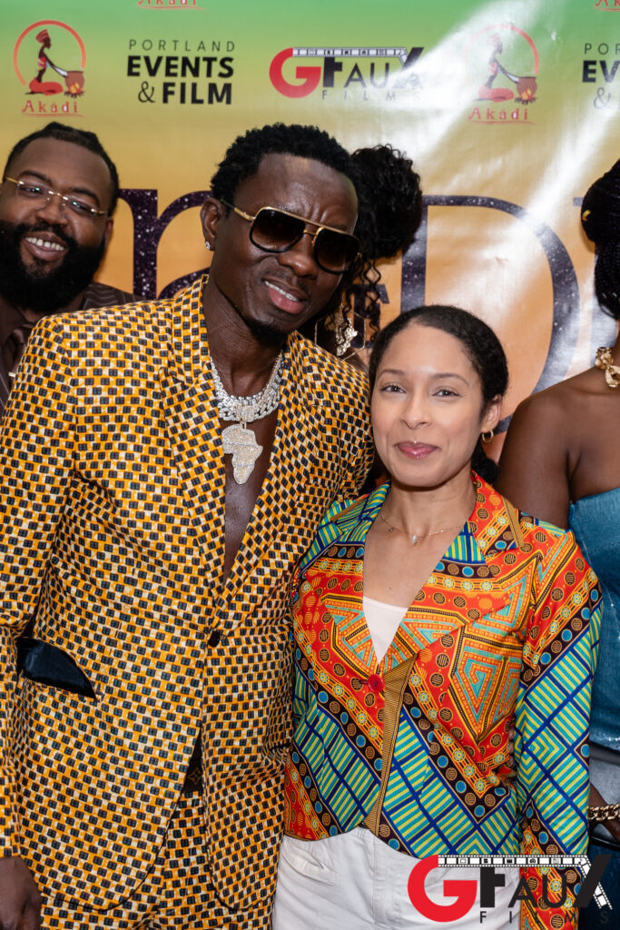 Two people in colorful patterned outfits posing